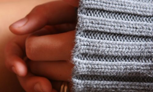 Photo of a woman's hands in her lap.